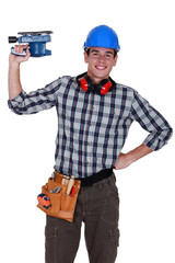 Young handyman holding electric sander