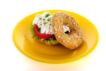 Bagel with cream cheese and herbs on plate