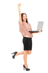 Full length portrait of a happy woman holding a laptop with rais