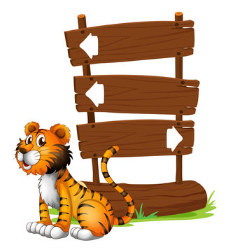 A tiger beside a wooden signboard