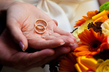 wedding rings on hands of newlyweds