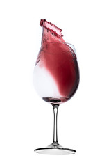 red wine splashing out of a glass, isolated on white