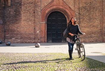 Woman walking with bicycle in Saint Stephen square, Bologna, Ita © pio3