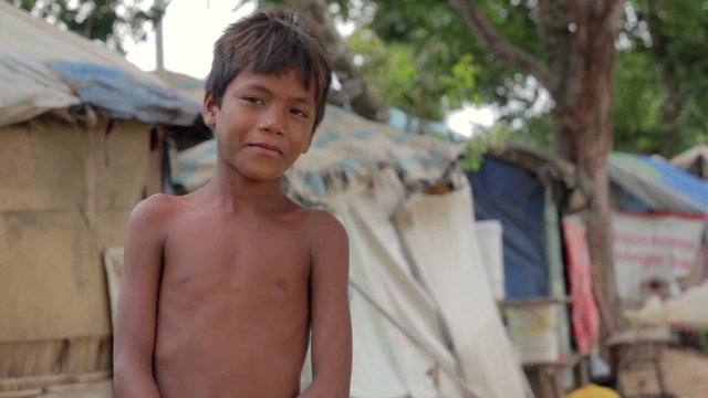 Cambodian boys in slum, shacks at background