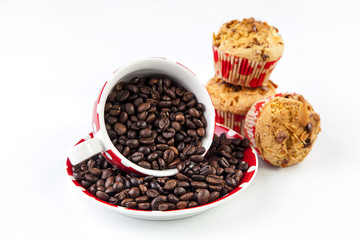Almond flakes muffins near a cup full of coffee beans