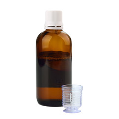 Syrup in a bottle with dosage cup