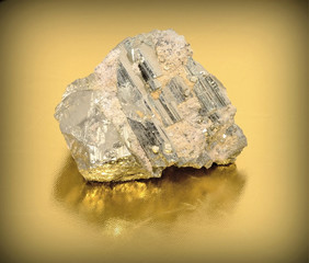 A close up of iron pyrite mineral on yellow background.