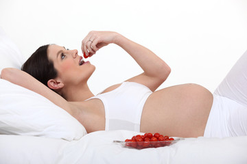 Obraz na płótnie Canvas Kobieta w ciąży jeść pomidory