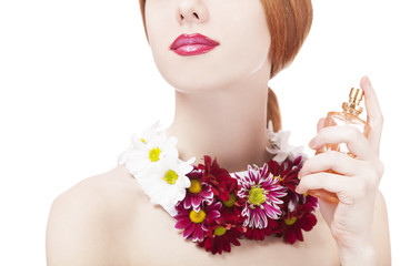 Fototapeta na wymiar Piękna dziewczyna redhead z kwiatów i perfum