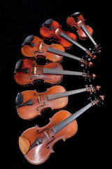 different sized violins on black