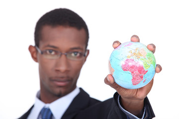 Concept shot of a businessman holding a miniature globe