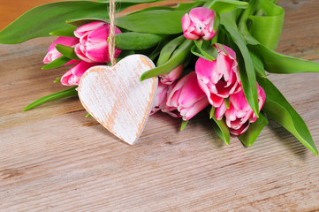 Holzherz und rose Tulpen auf einem alten Holt Brett