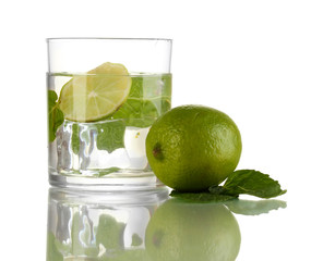 Glass of water with ice, mint and lime isolated on white
