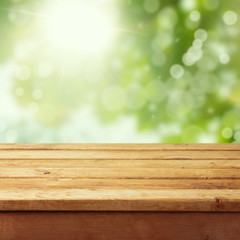 Lege houten dektafel met gebladerte bokeh achtergrond