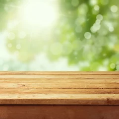 Crédence de cuisine en verre imprimé Printemps Table de terrasse en bois vide avec arrière-plan flou de feuillage