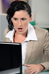 Shocked woman reading an e-mail