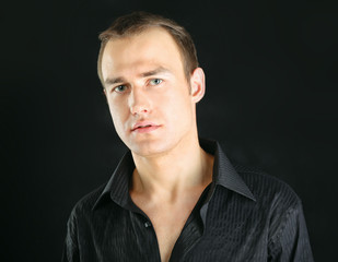 Portrait of successful business man standing on black background