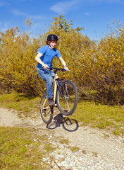 Fototapeta premium boy jumps with his dirt bike over natural ramps