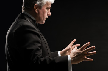 Closeup portrait of male orchestra conductor directing with his