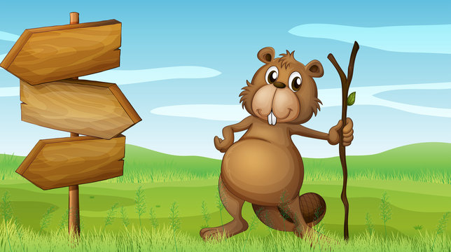 A beaver holding a wood beside a wooden signboard