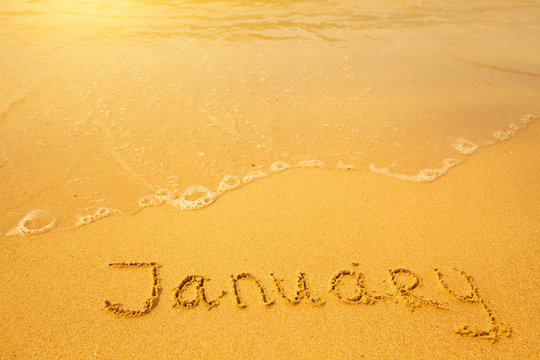 January - written in sand on beach texture