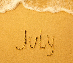 July - written in sand on beach texture