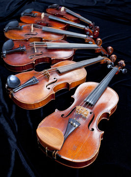 different sized violins on black