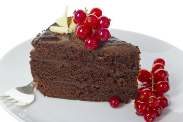 Slice of dark chocolate cake decorated with red berries.