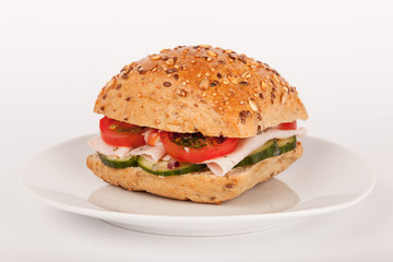 Mehrkorn Brötchen belegt mit Schinken und Salat auf Teller