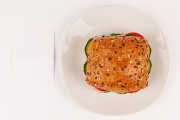 Mehrkornbrötchen von oben auf Teller mit Hinweisschild