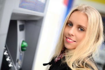 Fototapeta na wymiar Piękna kobieta za pomocą bankomatu