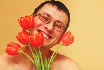 Romantic smiling young man with flowers