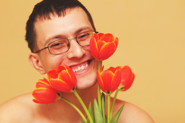 Romantic smiling young man with flowers