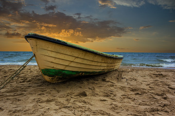 Fischerboot am Strand mit Sonnenuntergang