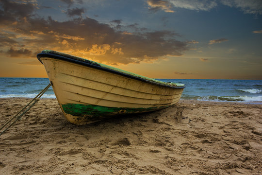 Fischerboot am Strand mit Sonnenuntergang