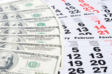 Banknotes of dollars on calendar sheets closeup