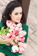 Beautiful young brunette woman with pink tulips