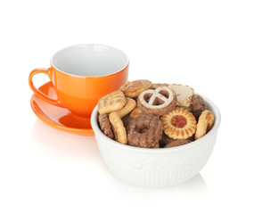 Various cookies in bowl and orange tea cup