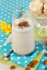 Glass of chocolate-cream cocktail on blue tablecloth close-up