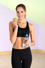 Young woman with water after workout at gym