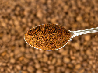 Ground coffee in silver spoon