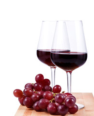 two wine glasses with red wine and grapes