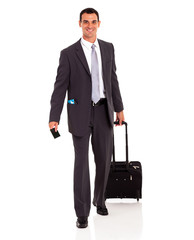 businessman walking with trolley bag and passport