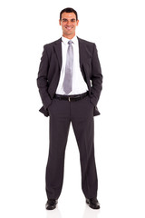 young businessman studio portrait both hands in pockets
