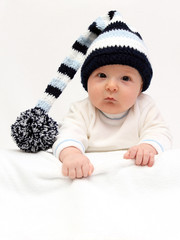 Baby with knitted hat looking