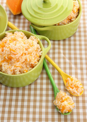 Taste rice porridge with pumpkin in saucepans
