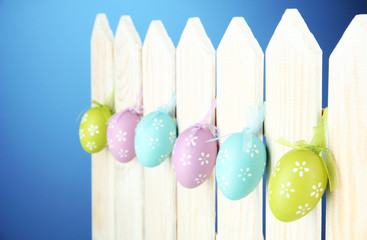 Art Easter background with eggs hanging on fence