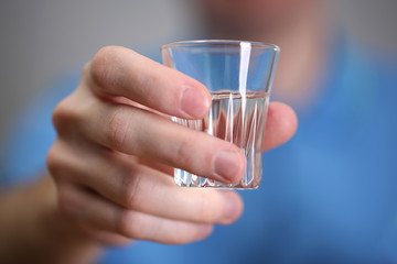 Man hand with glass of vodka , close up