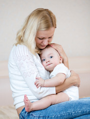 mother embracing baby boy indoors