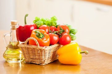 Healthy food fresh vegetables in basket and bottle with oil on t